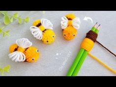 crocheted pencils with two yellow and white fish on them next to green leaves