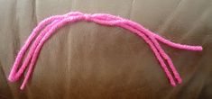 the pink string is attached to the back of a brown leather couch with white stitching on it