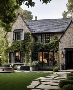 a large stone house with lots of windows and ivy growing on it's walls