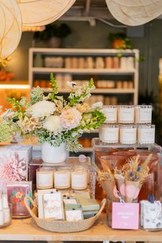 a table topped with lots of candles and flowers next to boxes filled with small items