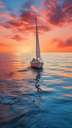 a sailboat floating in the ocean at sunset or sunrise with pink and blue clouds