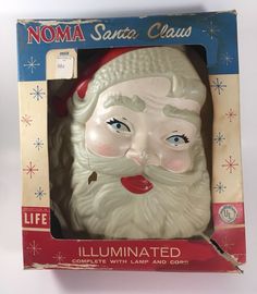 an old santa claus christmas ornament in its box