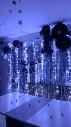 a room filled with lots of shiny balloons and stars hanging from the ceiling above it