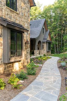 a stone walkway leading to a house in the woods