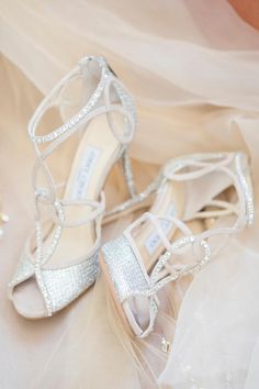 the bride's shoes and veil are laying on the bed sheet in her wedding dress