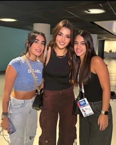 three girls are posing for the camera in an airport