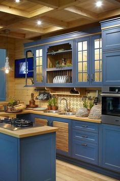 a kitchen with blue cabinets and wooden floors