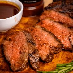 some steaks are on a cutting board with sauce