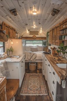 the interior of an rv with wood flooring and white cabinets, including a bed