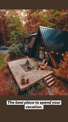 a person sitting on a wooden deck in front of a small cabin surrounded by trees