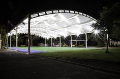 an empty soccer field at night with lights shining on the grass and trees around it