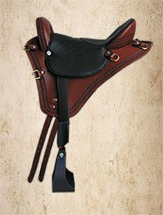 a brown and black saddle hanging on the wall