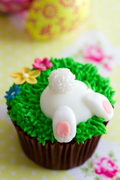 a cupcake decorated with green frosting and white icing