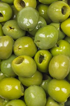 green olives are piled up in a bowl