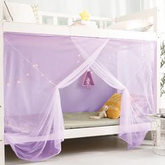 a white bed with purple mosquito netting on it and a stuffed animal in the corner