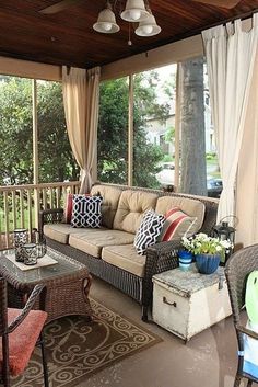 a covered porch with furniture and curtains