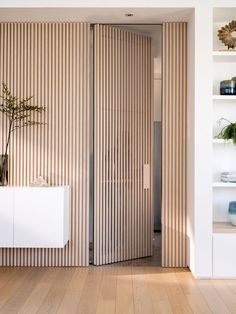 a room with wooden flooring and sliding doors that have vertical slats on them