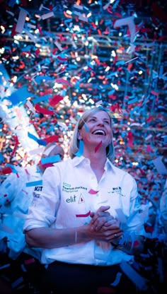 a woman in white shirt surrounded by confetti and streamers