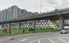 an artist's rendering of people walking in front of a building with large metal tanks on it