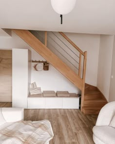 a white couch sitting under a wooden stair case