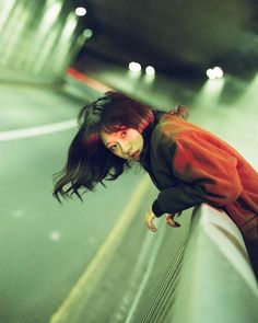 a woman leaning on the side of a wall