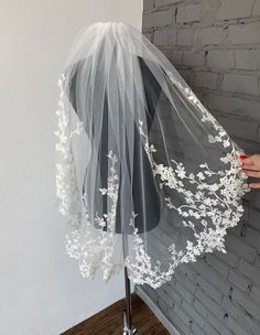 a bridal veil on a mannequin with white flowers and leaves in it