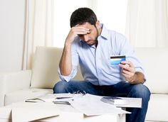 a man sitting on a couch holding a credit card