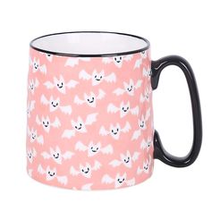 a pink and black mug with white bats on it