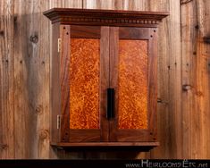 a wooden cabinet with an intricate design on the front and back sides, against a wood paneled wall