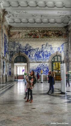 two children are standing in the middle of a room with blue and white tiles on the walls