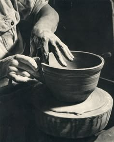 a person is making a bowl out of clay with their hands on the pottery wheel