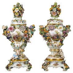 two vases with flowers on them sitting side by side in front of each other