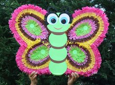 a person holding up a paper plate shaped like a butterfly