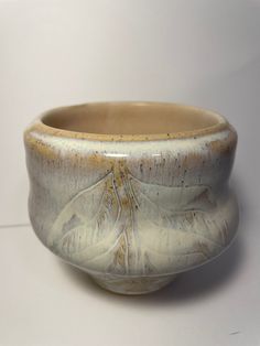 a white and brown ceramic bowl sitting on top of a table