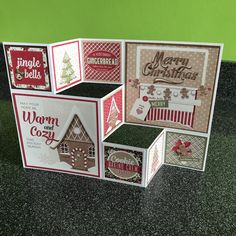 four christmas cards stacked on top of each other in front of a green wall and black countertop