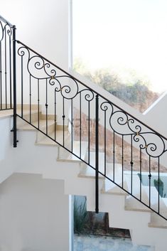 a stair case with wrought iron railing and handrail