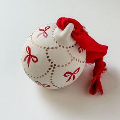 a white ornament with red bows on it