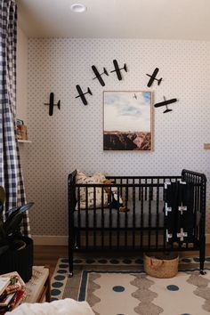 a baby crib in the corner of a room with black and white wallpaper