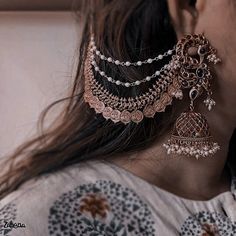 a close up of a woman's ear wearing earrings