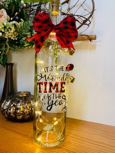 a wine bottle with a red bow on it that says it's the most wonderful time of the year