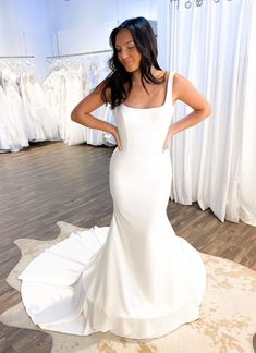 a woman standing in front of a white dress