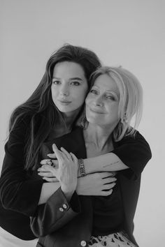 two women hugging each other in black and white