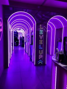 the inside of a building with purple lighting and neon signs on the walls that read level up