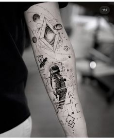 a man's arm with an astronaut and space themed tattoo on the left forearm