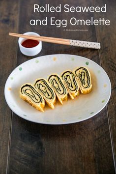 rolled seaweed and egg omelette on a white plate with chopsticks