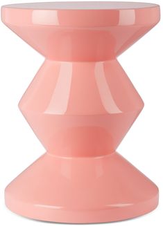 a pink vase sitting on top of a white table