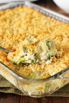 a casserole dish with broccoli and cheese in it on a wooden table