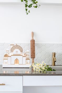 a kitchen counter with flowers on it next to a cutting board