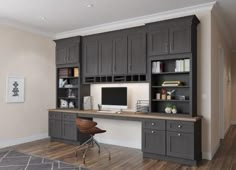 a home office with black cabinets and a desk