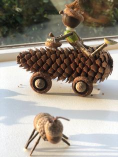 two small pine cones are sitting on top of each other, and one is holding a wrench